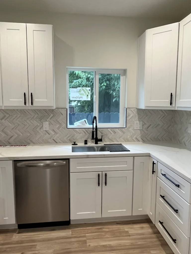 A kitchen with white cabinets and stainless steel appliances.