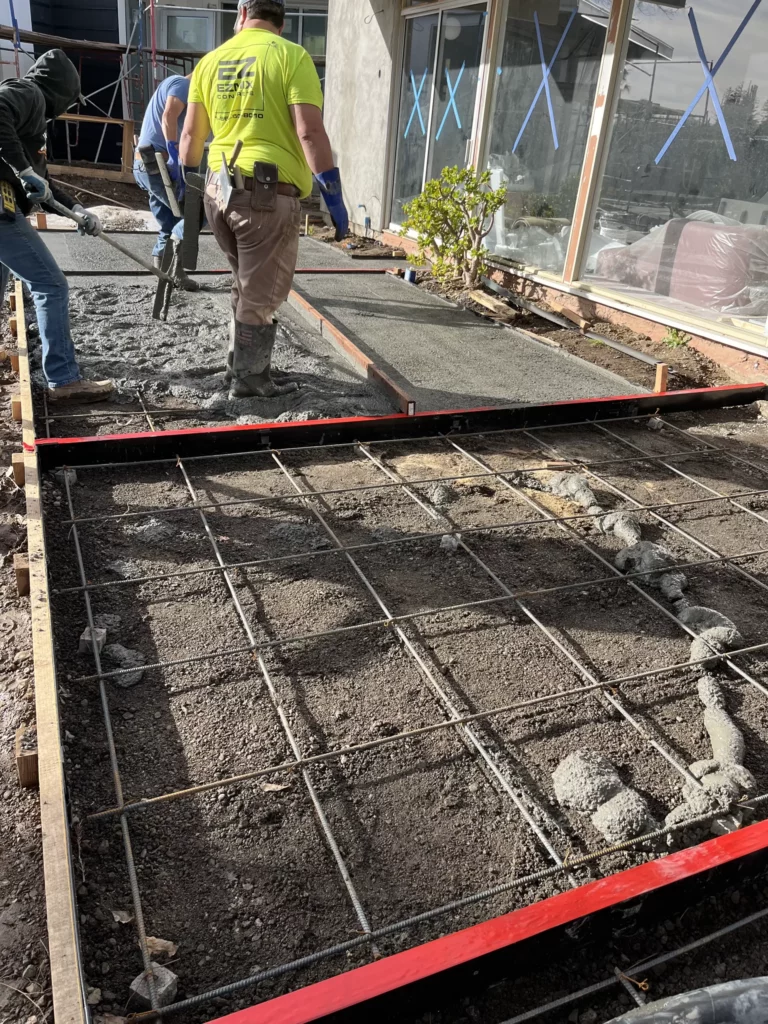 A group of construction workers are working on a concrete floor.