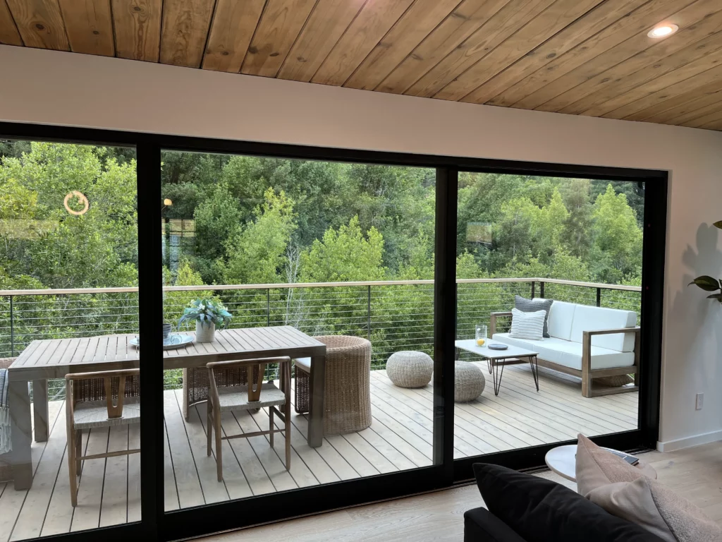 A living room with sliding glass doors and a deck. general construction contractors