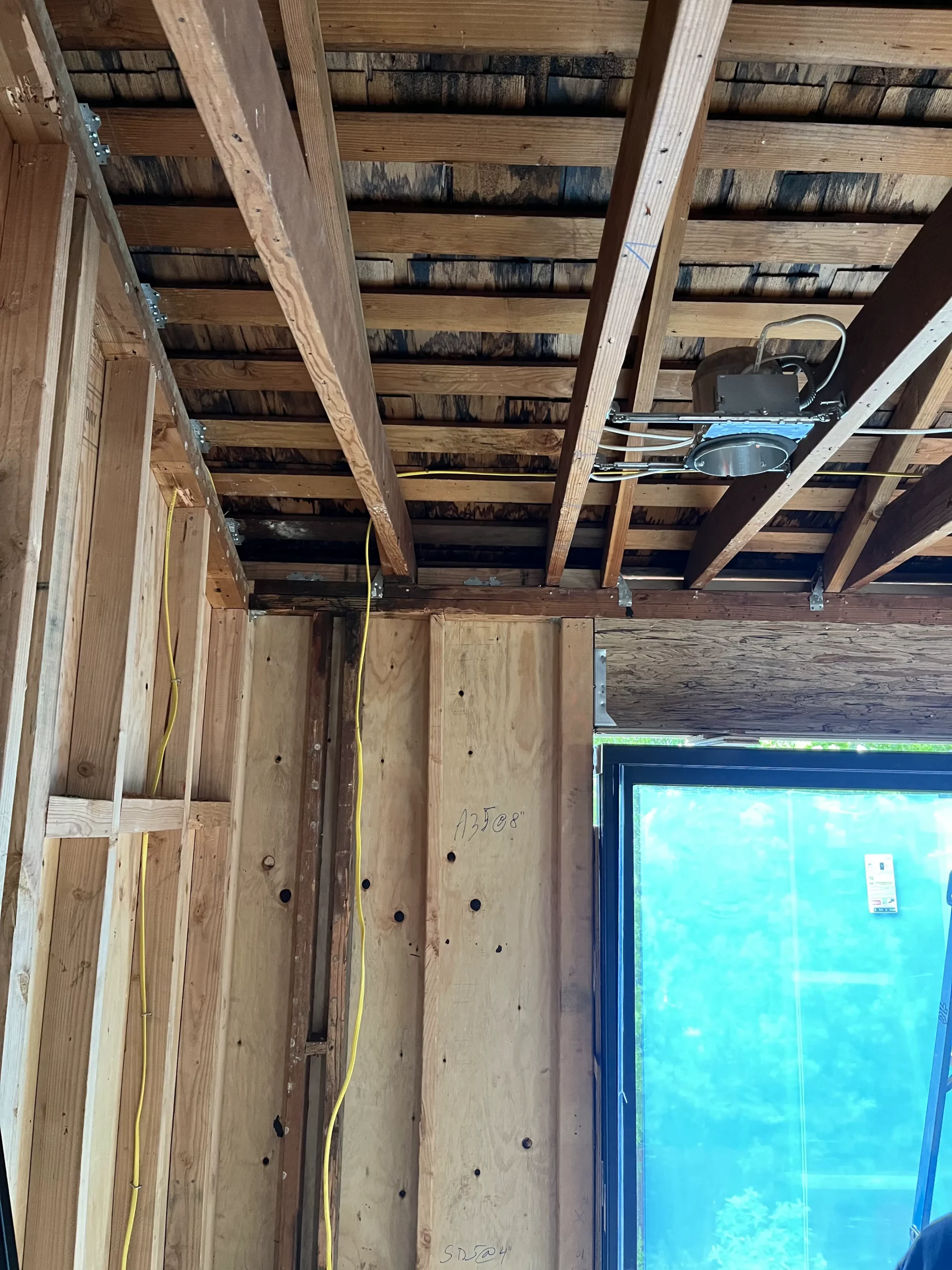 An unfinished room with wood beams and a window.