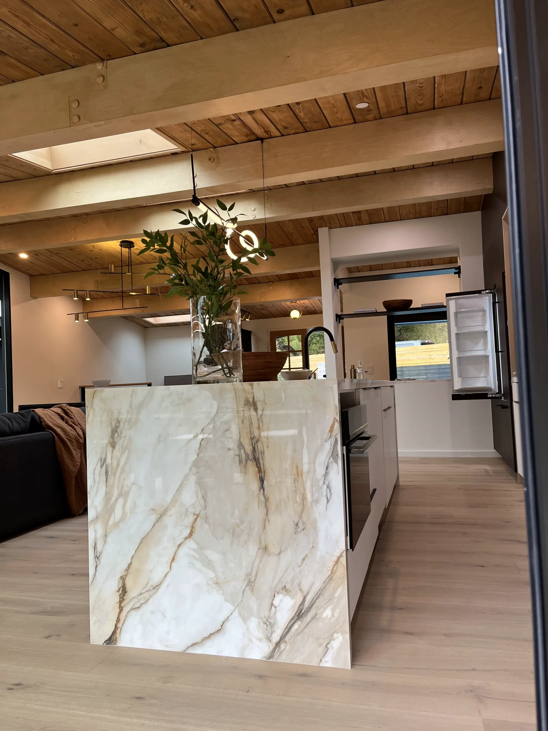 A kitchen with marble counter tops and wood floors.