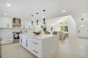 A kitchen with white cabinets and hardwood floors.