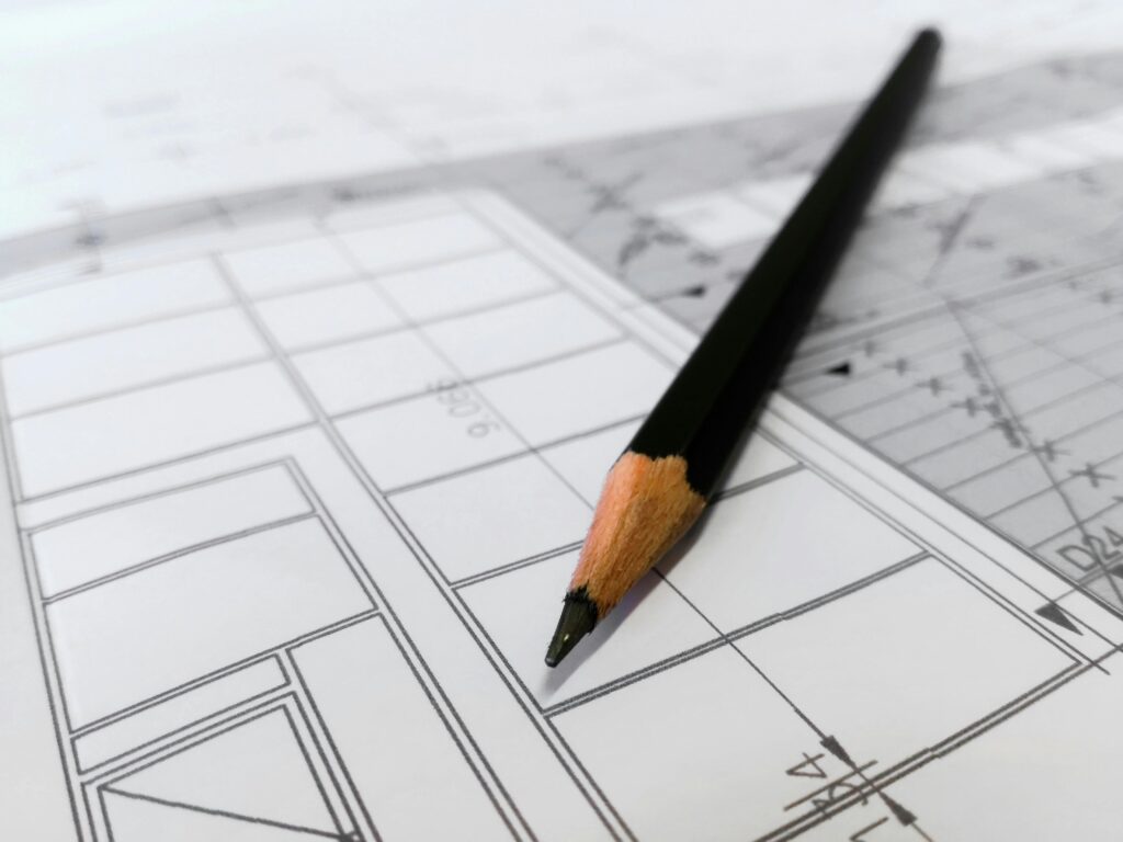 pexels-photo-268362-268362 - Cardoza Builder | General Construction Experts Detailed image of a black pencil resting on architectural blueprints, ideal for design and planning themes.